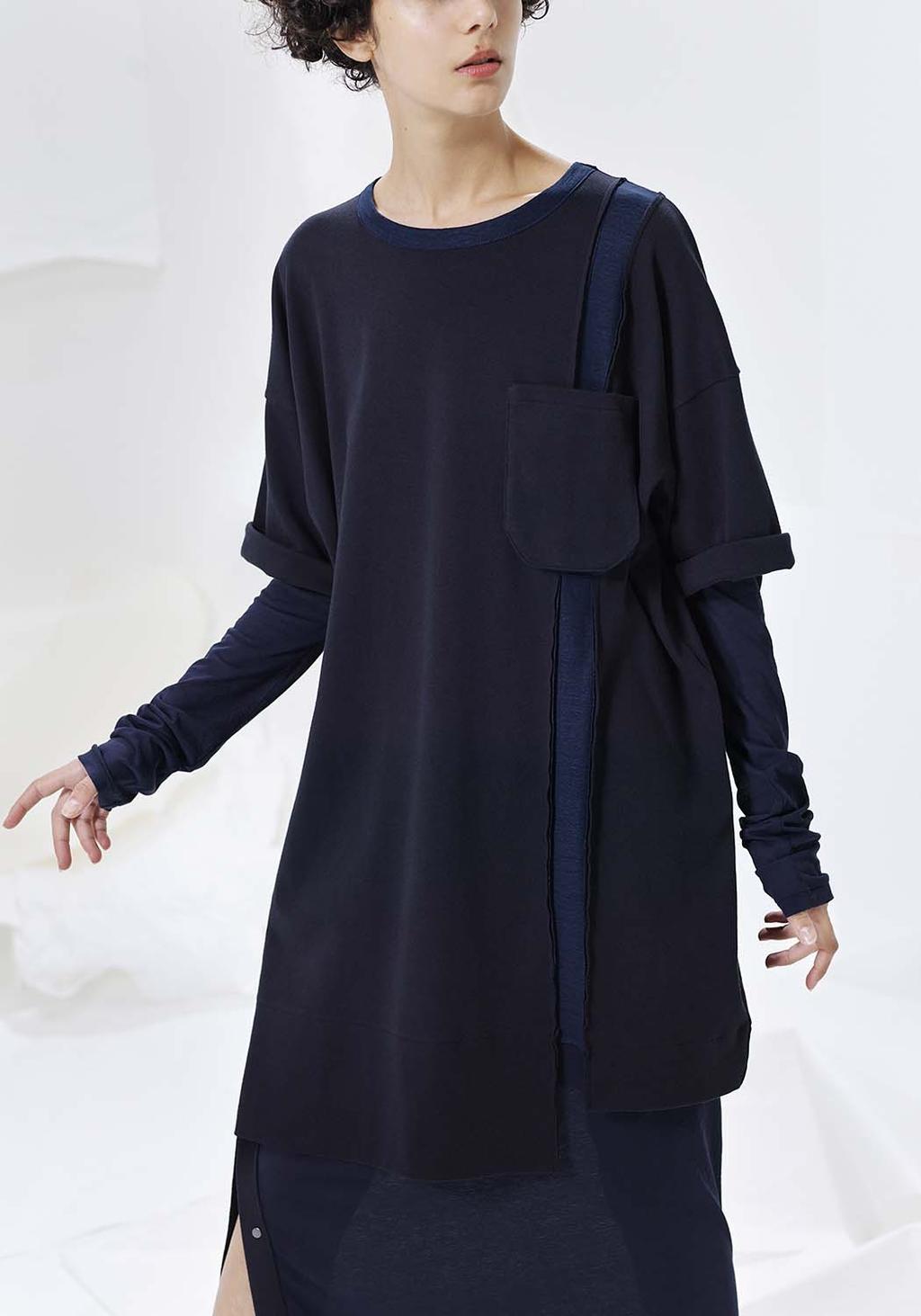 A dark navy tunic with a patch pocket and layered sleeves, close-up