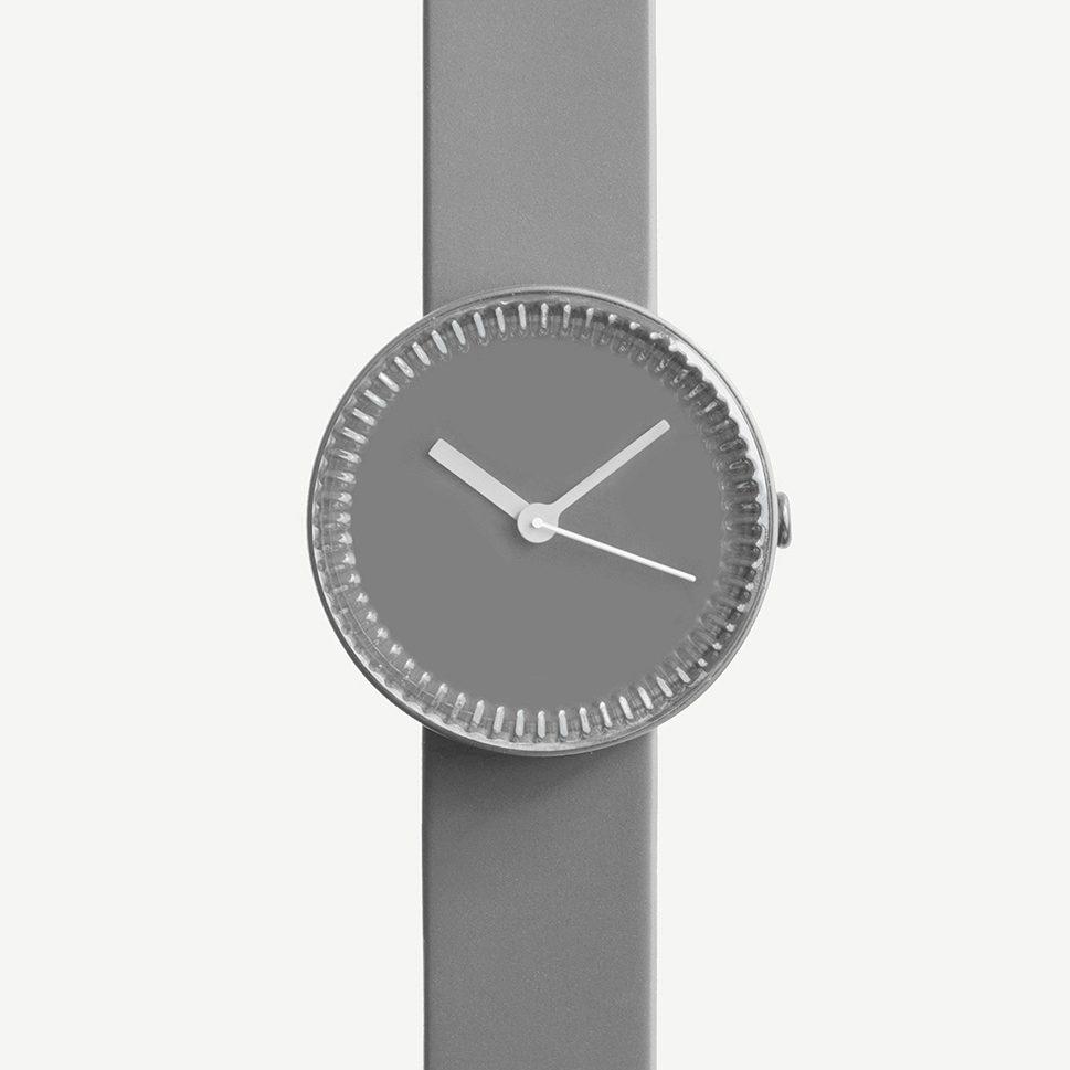 A wristwatch with a grey dial and a ridged bezel resembling a bottle cap