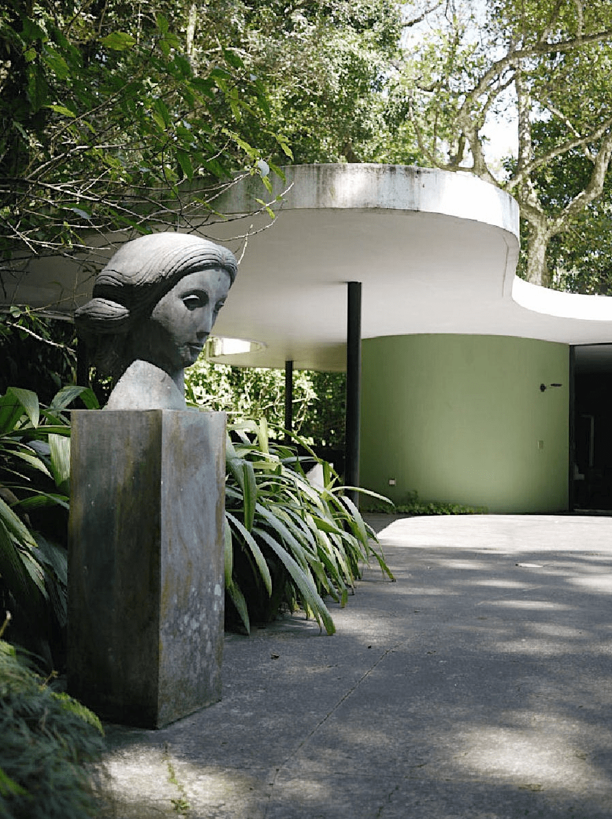 A sculptural head at the entrance to Casa das Canoas, set among tropical greenery