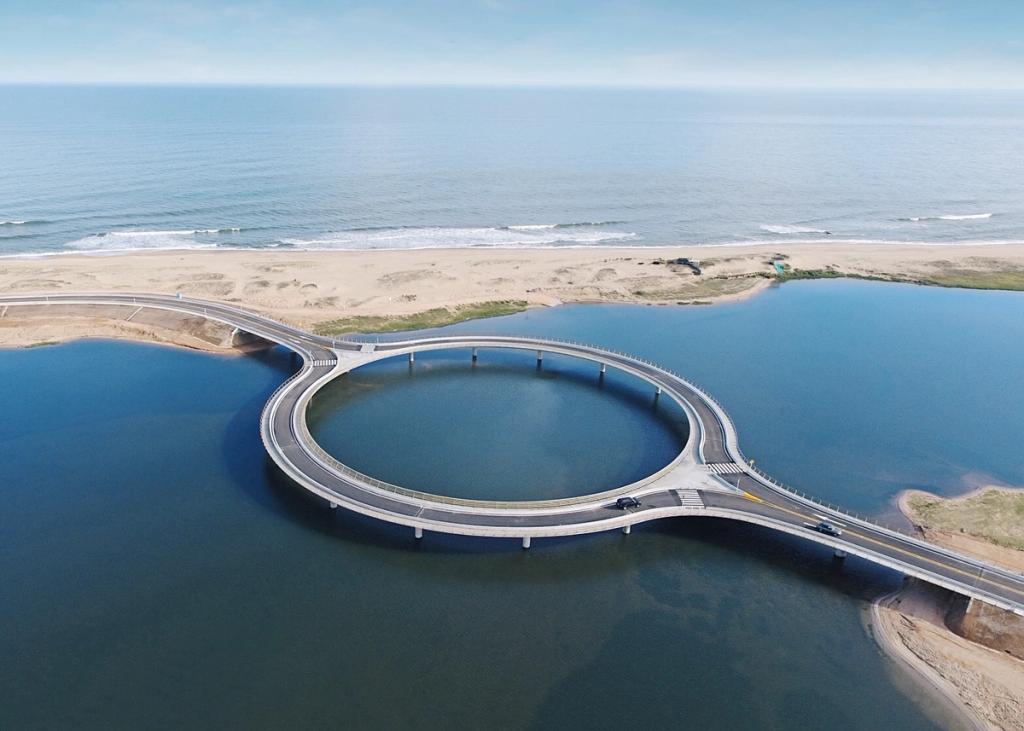The circular Round Bridge between the lagoon and the ocean beach in Uruguay, aerial view