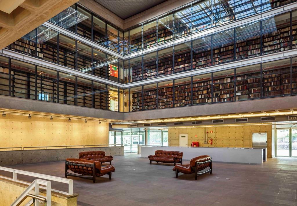 The multi-tiered atrium of the Brasiliana Library, with glazed bookshelves and leather sofas in the foyer