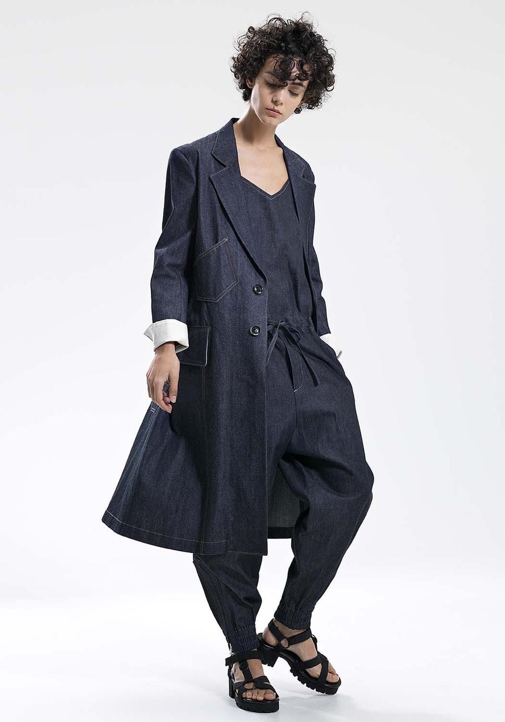A model in a denim coat and wide denim trousers with sandals