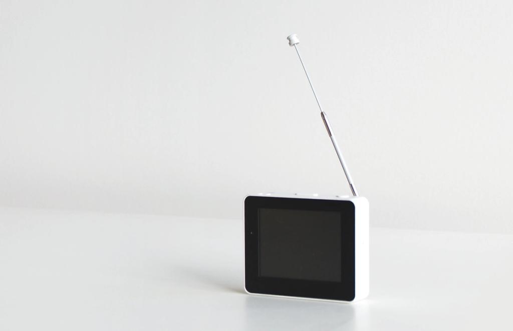 White compact television with a pull-out antenna on a table
