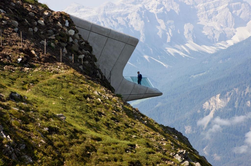 Бетонный объём Messner Mountain Museum на склоне горы Кронплатц, человек на смотровой площадке