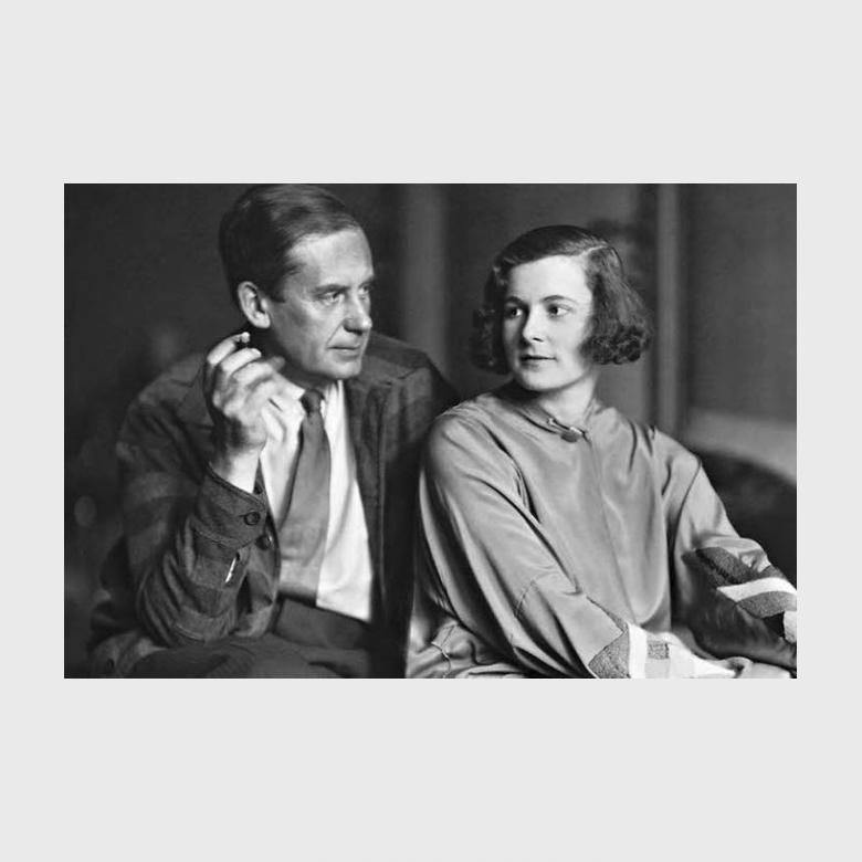 Black-and-white portrait of Walter Gropius with a pipe, seated beside a young woman