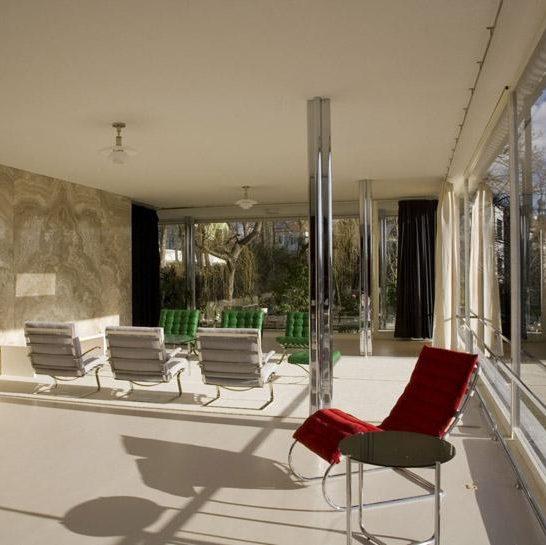 The interior of Mies van der Rohe's Villa Tugendhat with Barcelona chairs and a red chaise longue