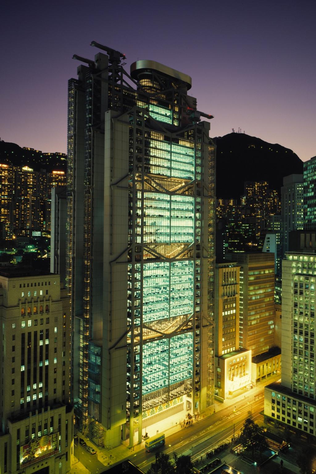 The illuminated HSBC tower in Hong Kong at dusk against a backdrop of city lights