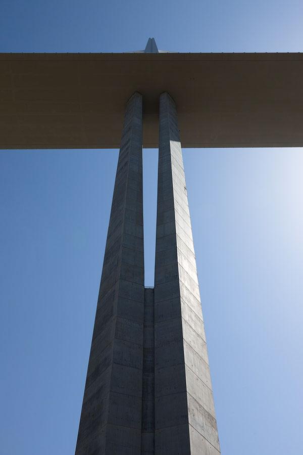 The Millau Viaduct from below: a white pylon with a fan of stay cables above the deck receding into the distance