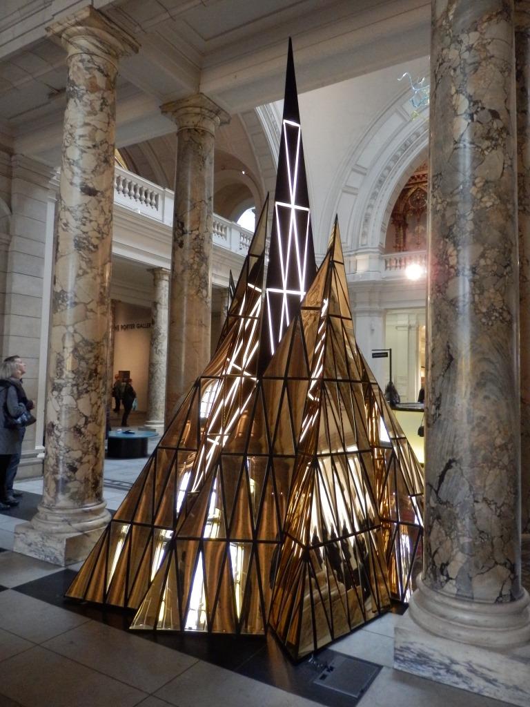 Gareth Pugh's mirror-gold triangular pyramid Ceremony installation among the marble columns of a museum