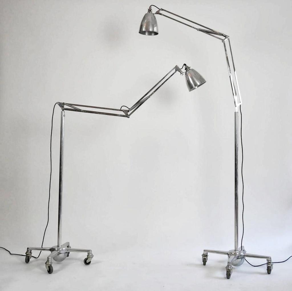 Хромированные напольные лампы Anglepoise на колёсных основаниях у белой стены
