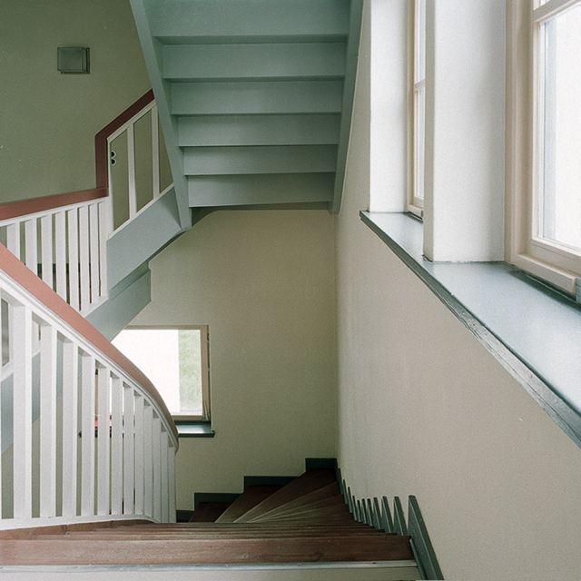 Interior of Auerbach House: a staircase with white railings and wooden treads beside a window