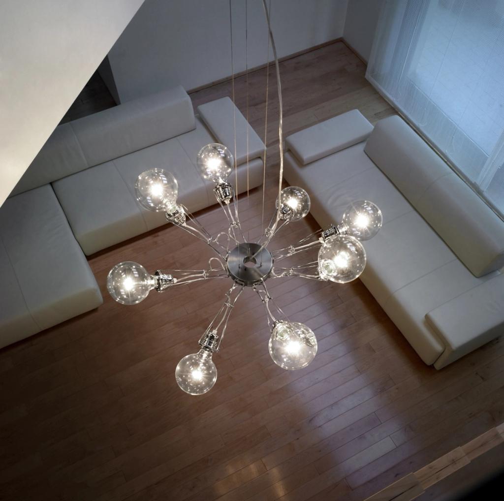 Подвесная люстра Lumina с прозрачными шарообразными лампами над белым диваном, вид сверху