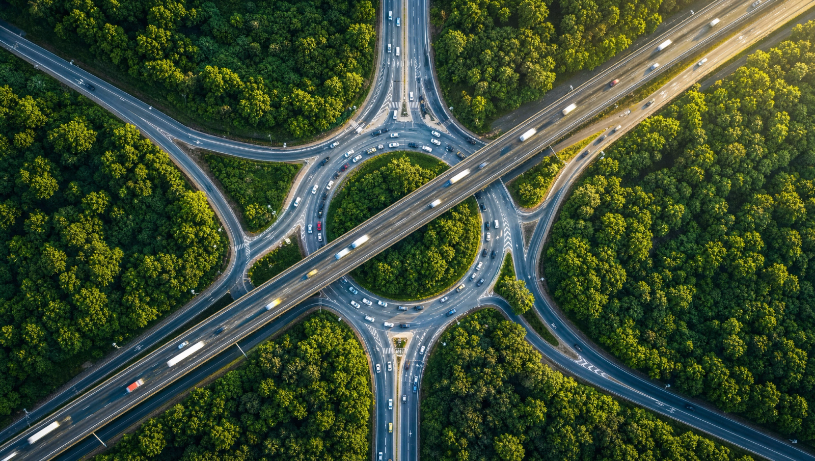Aerial view of a motorway interchange through forest, roads converging — symbolizing the path back to Germany's GKV