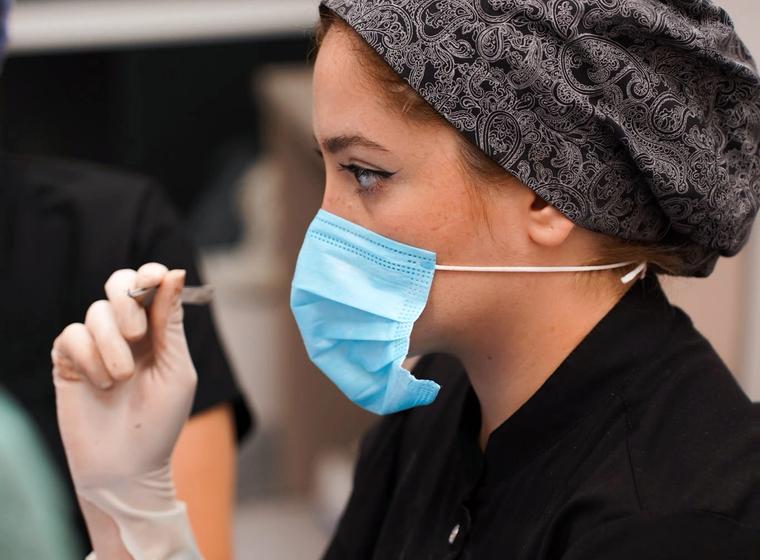 Clinician wearing a surgical mask and cap during clinical preparation