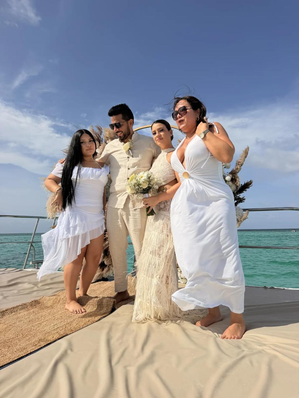Jeunes mariés fêtant avec leur famille après une cérémonie privée en catamaran à Punta Cana