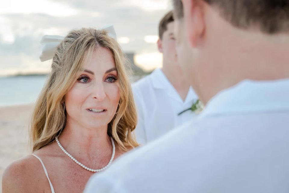 Mariée écoutant les vœux lors d’un elopement sur une plage de Punta Cana
