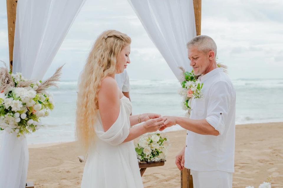 Couple échangeant les alliances lors d’un elopement privé sur une plage de Punta Cana