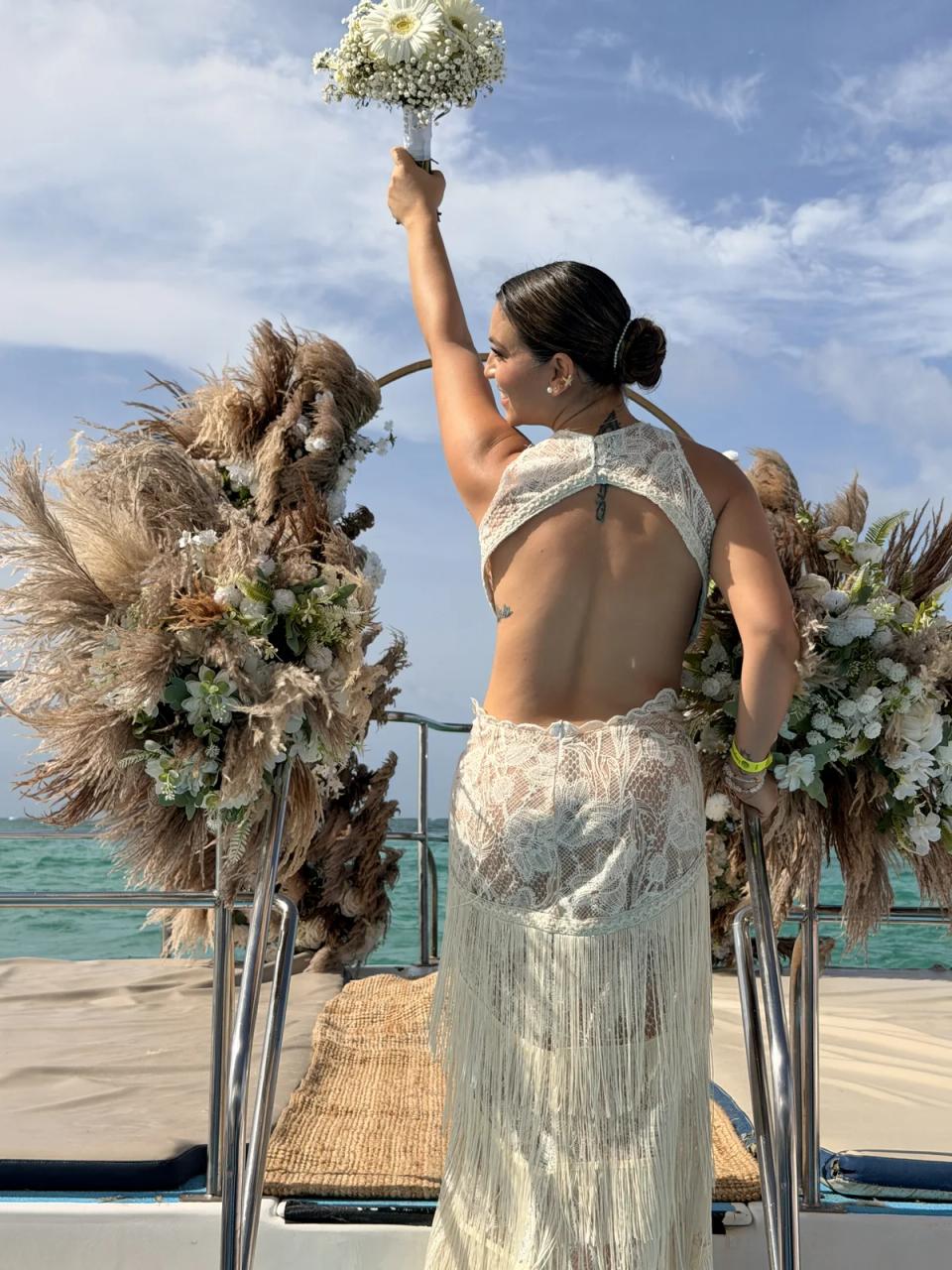 Mariée célébrant près d’une arche florale de pampas à bord d’un catamaran à Punta Cana