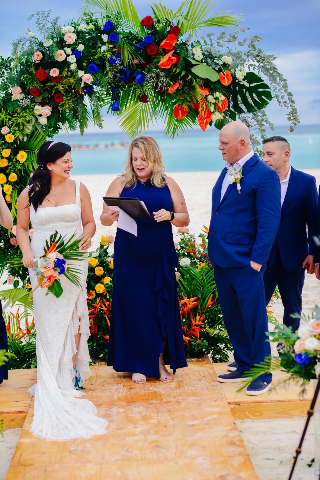Bride and groom smiling during a colorful beach wedding ceremony in Punta Cana