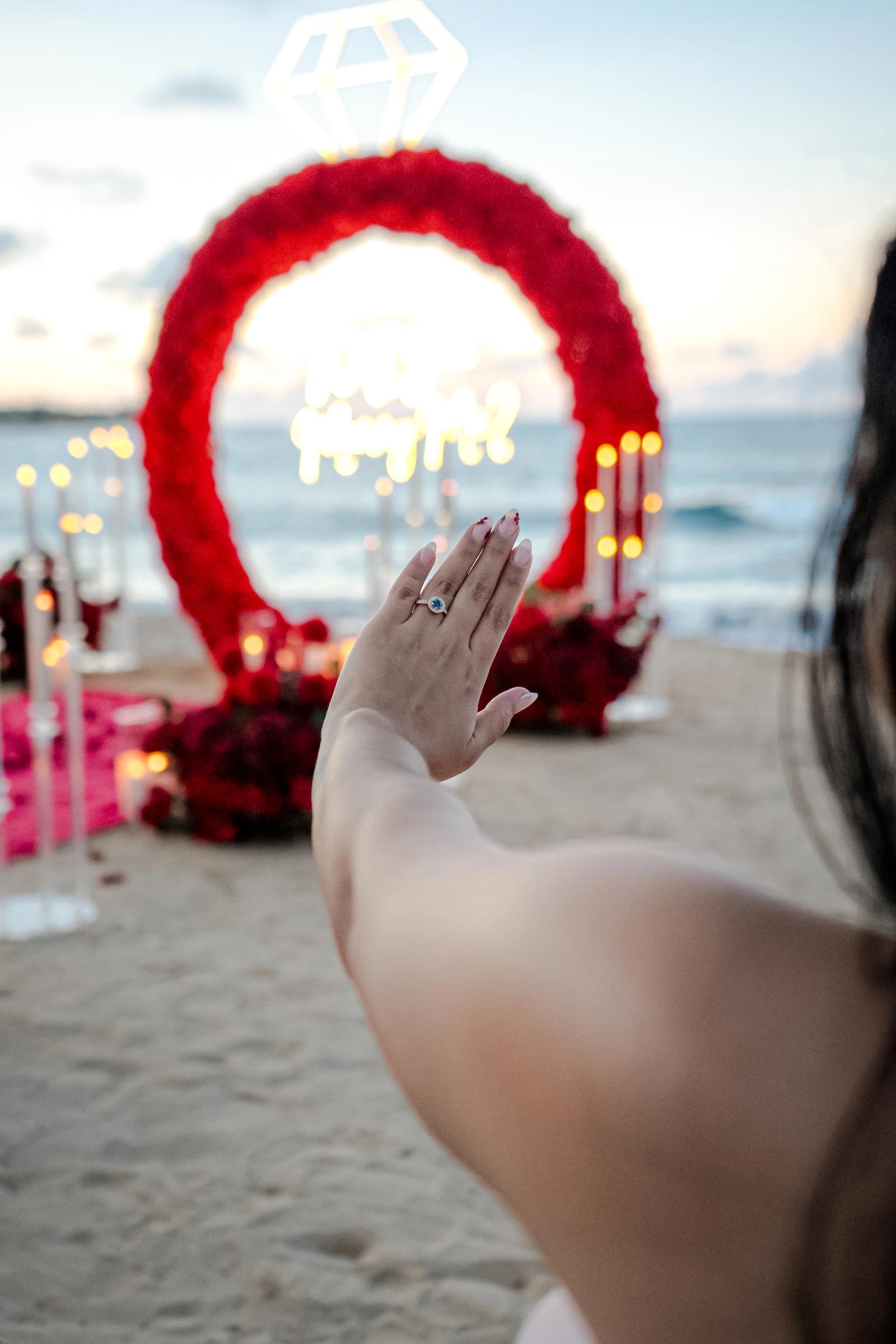 Endless Love: Engagement ring on a hand in front of the red floral decoration. Endless Love: Engagement ring on a hand in front of the red floral decoration.