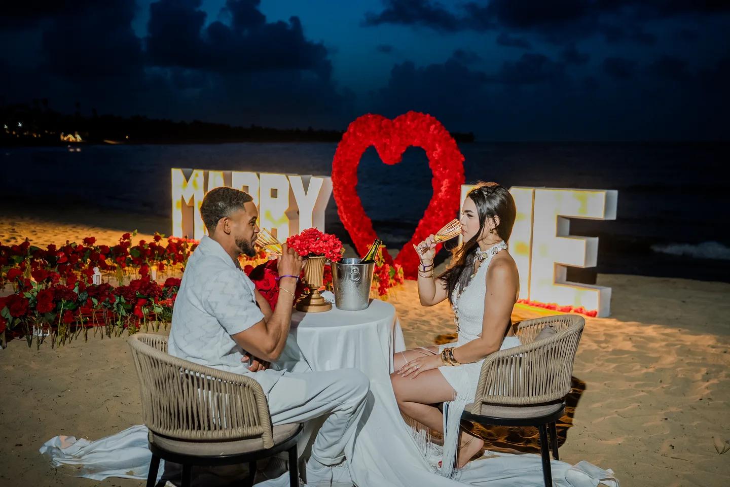 Couple celebrating at a beach proposal dinner