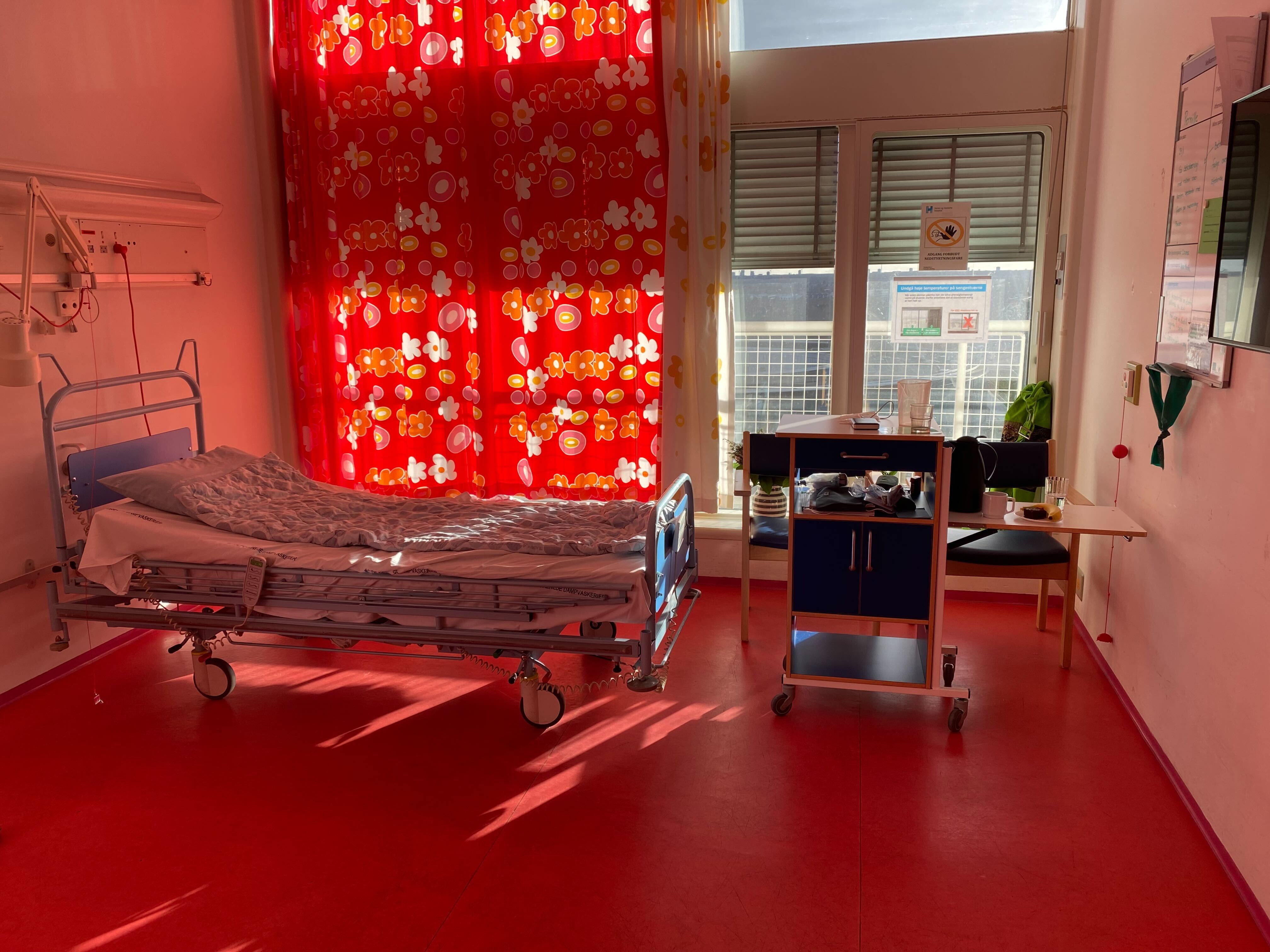 A patient room at Herlev Hospital with soothing red colors on the floor and curtain. Color design by Paul Gernes.