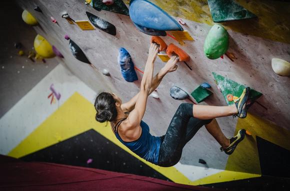 Woman climbing in a gym to illustrate a founders mentality