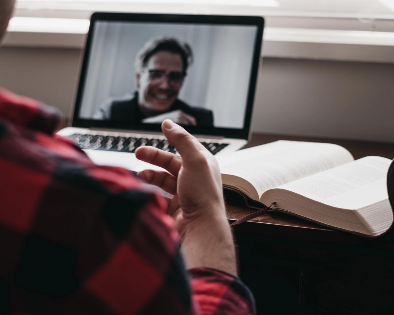 Man sits in front of computer during an online coaching session