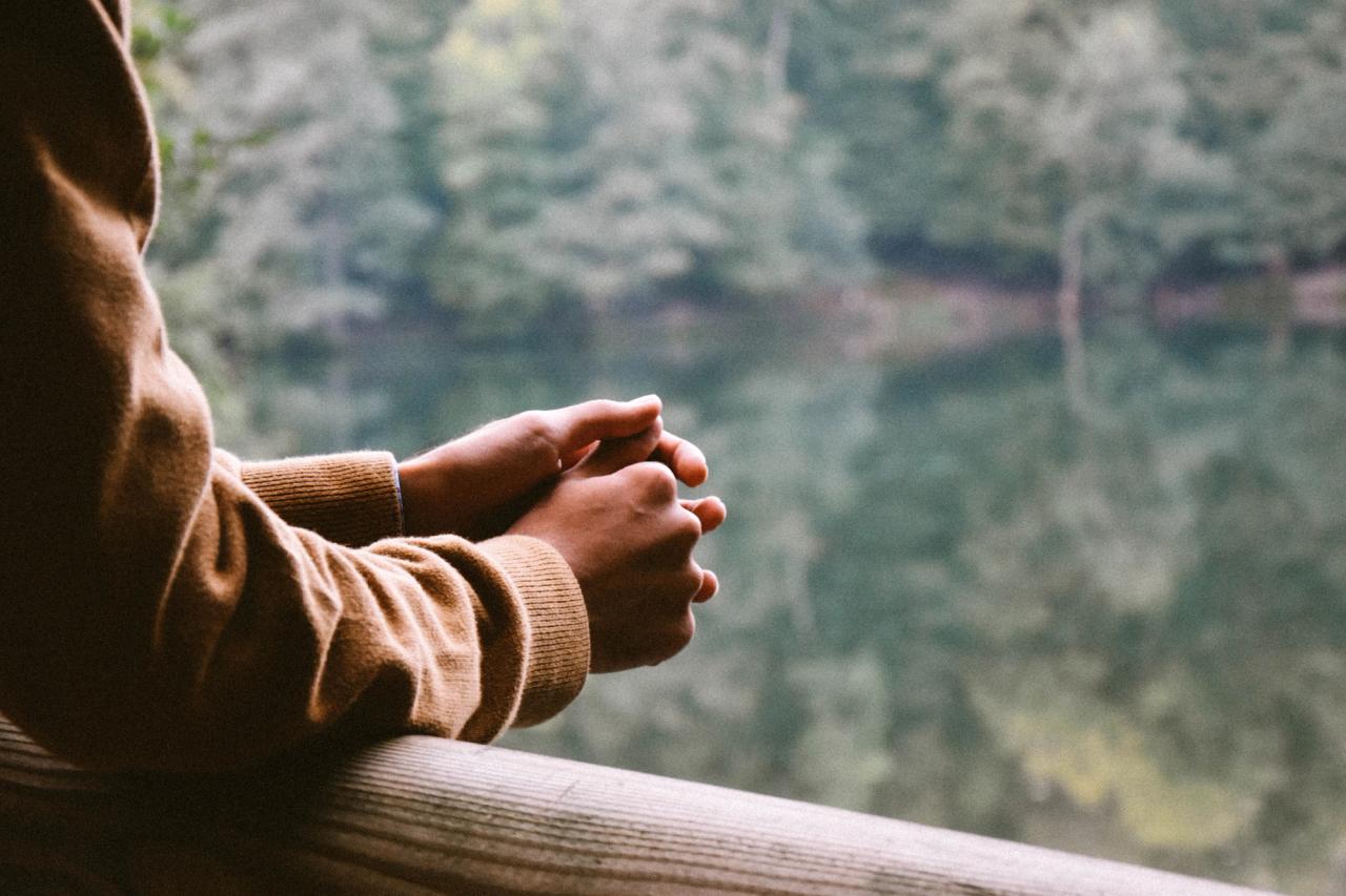 Image of a relaxed person looking at a forest lake.