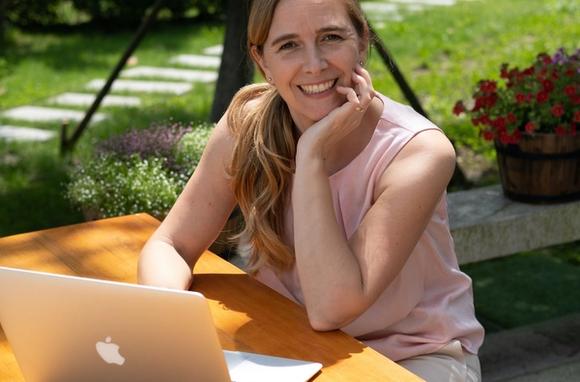 Session coach sits in front of computer while having an online business coaching session on the Session platform