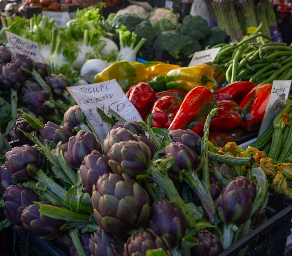 Fresh artichokes and peppers at an Italian market stall
