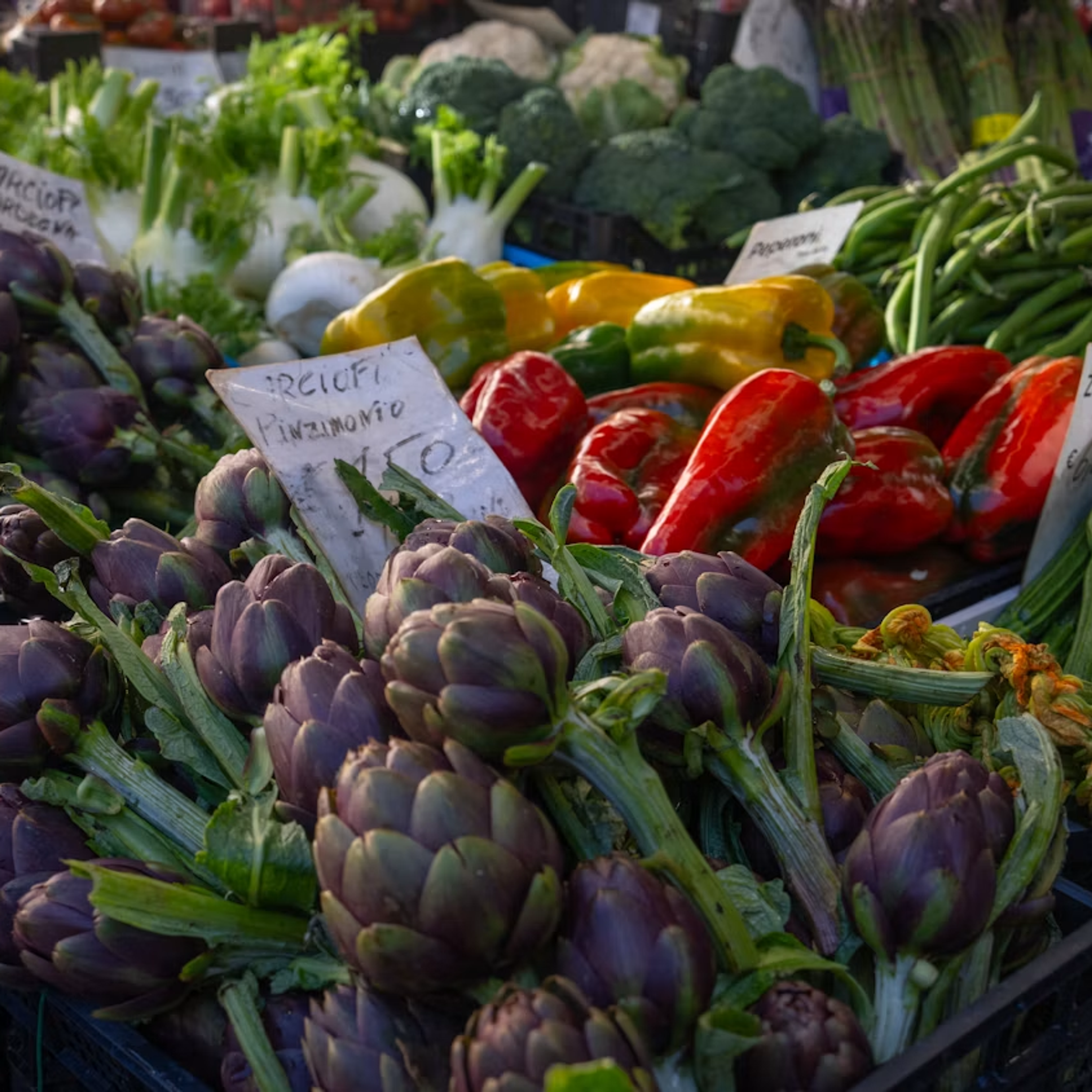 Fresh artichokes and peppers at an Italian market stall