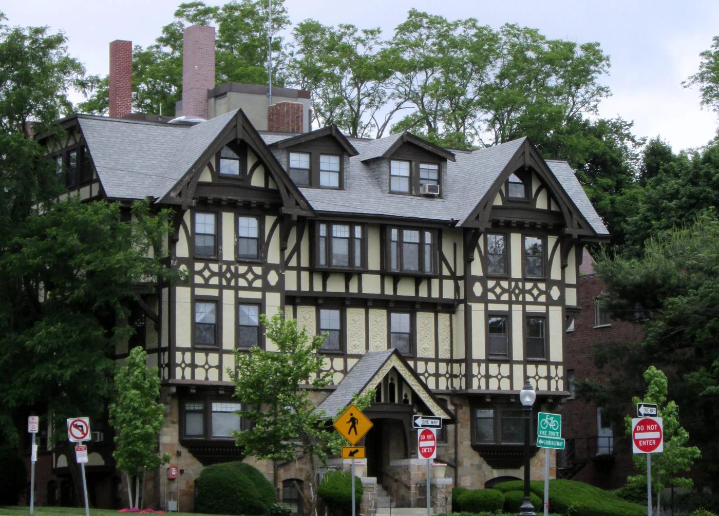 Large Tudor revival house with a slate roof and multiple gabled dormers