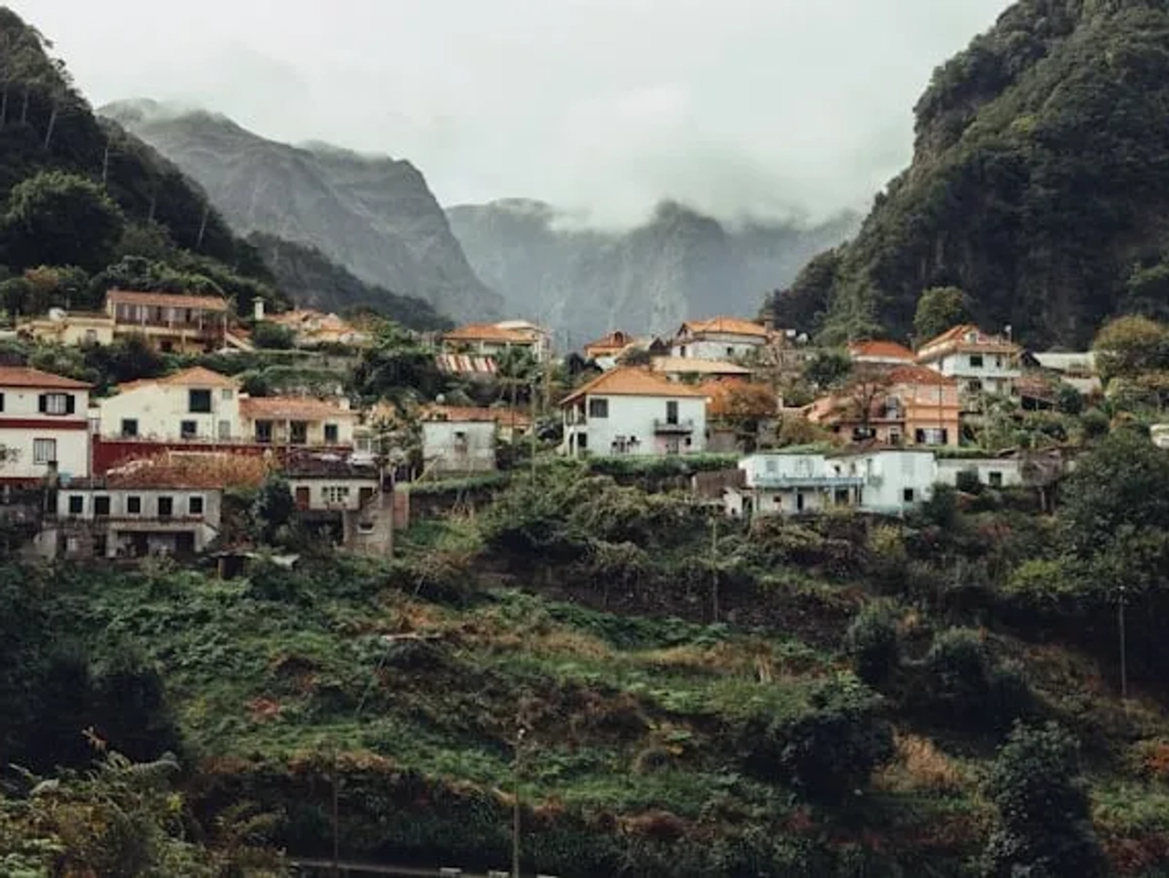 aldeia na madeira com casas numa encosta com nevoeiro