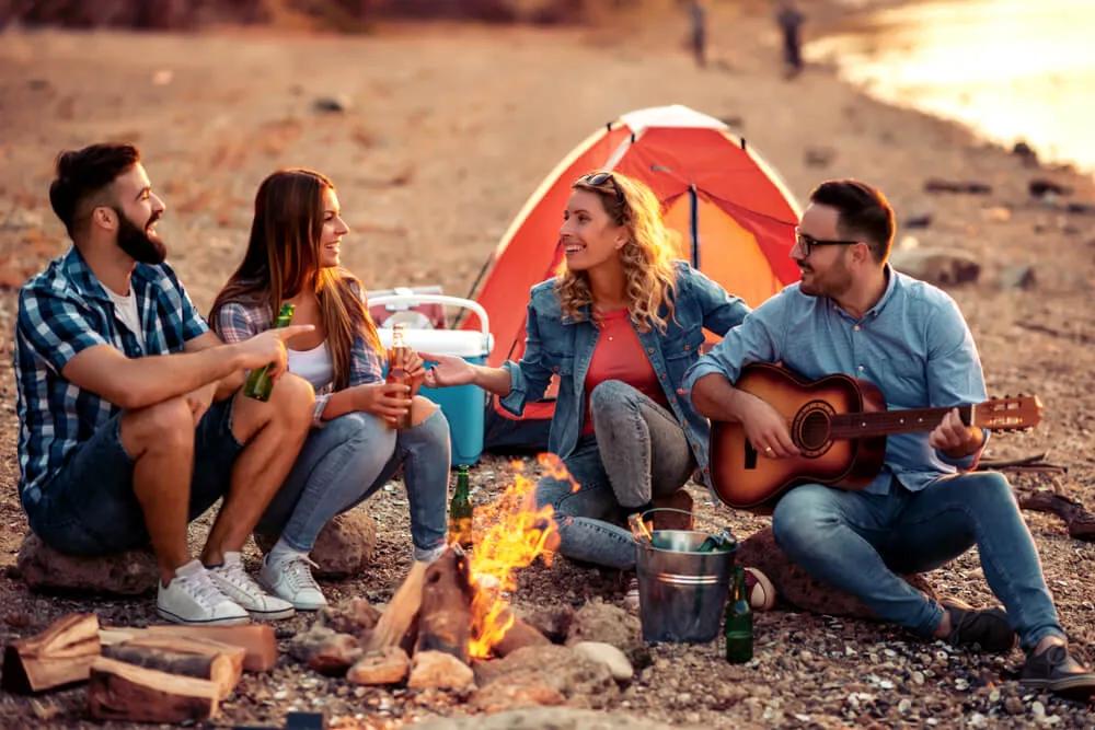 jovens sentados a volta de uma fogueira num campismo