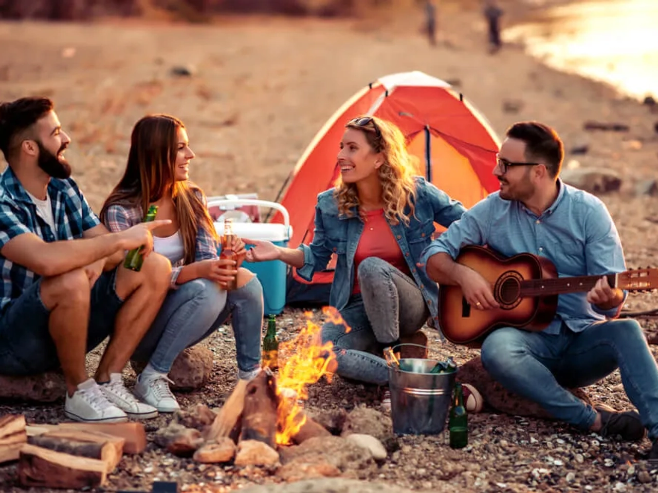 jovens sentados a volta de uma fogueira num campismo