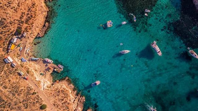 boats in crystal clear water in Comino, Malta