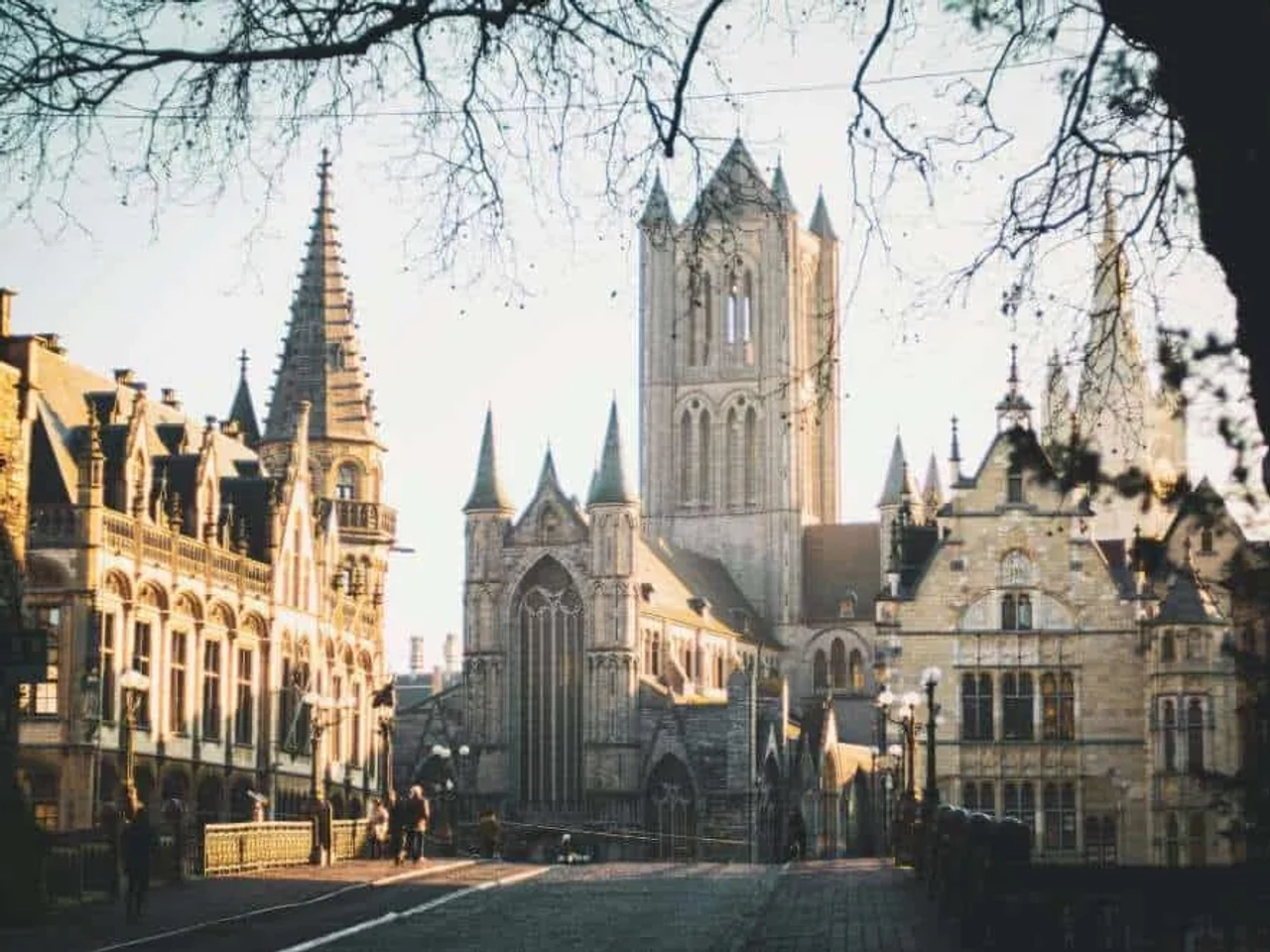 Vista de edificios históricos y una torre en Bélgica al atardecer.