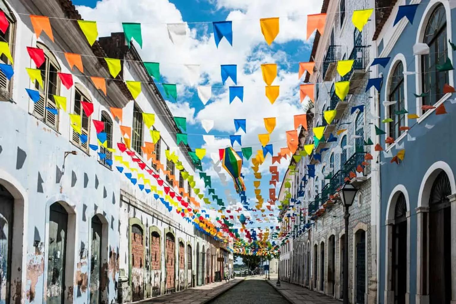 Calle decorada con banderines de colores en un día soleado.