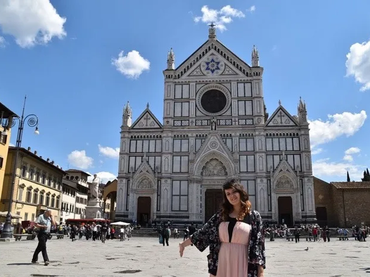 Mujer sonriente frente a la Basílica de Santa Croce en Florencia.
