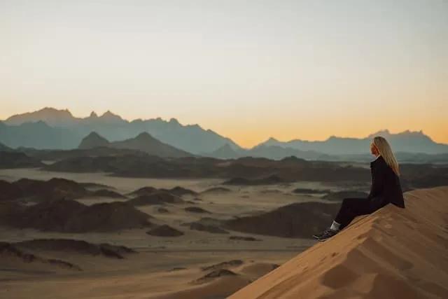 Woman standing in dunes in Arabia