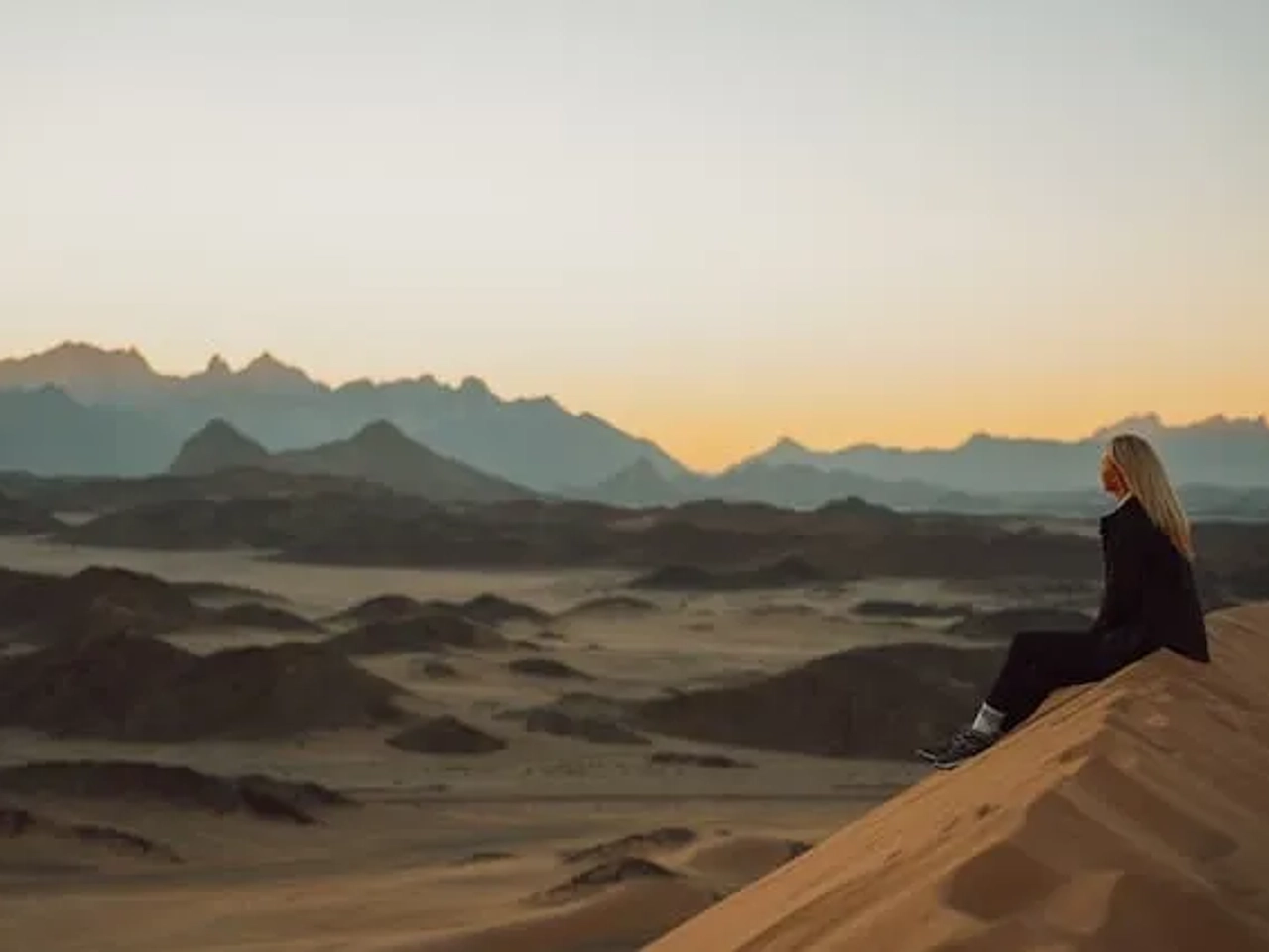 Woman standing in dunes in Arabia