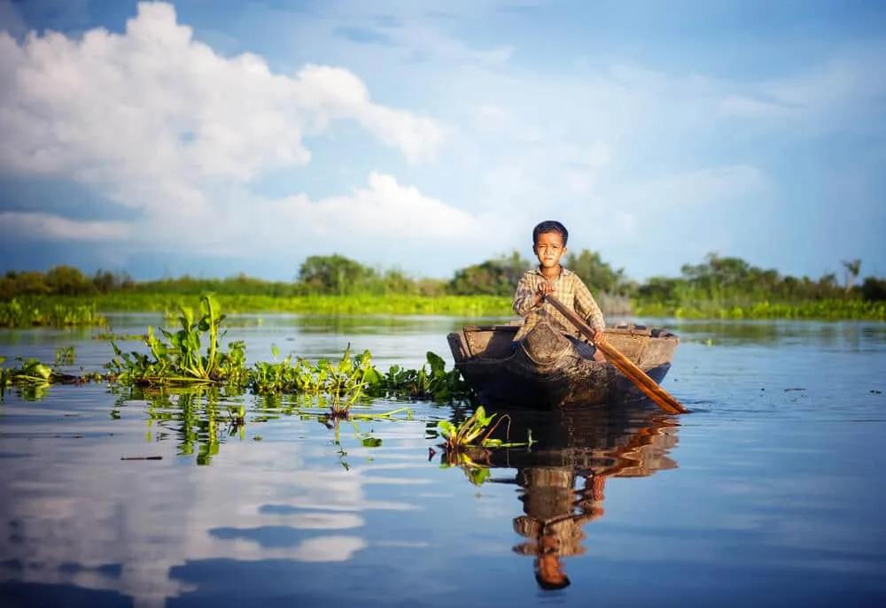 criança num barco no lago tonle sap camboja