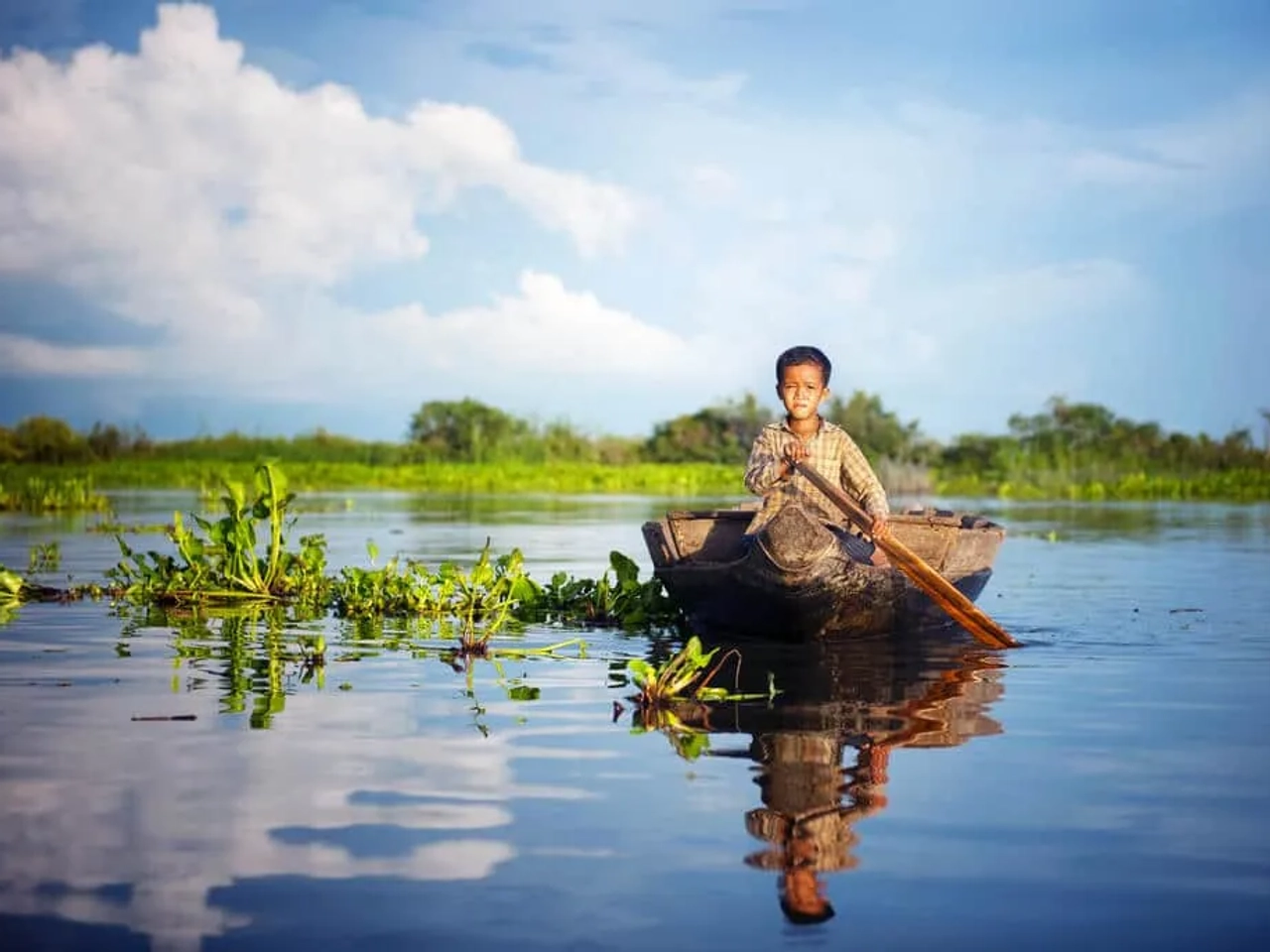 criança num barco no lago tonle sap camboja