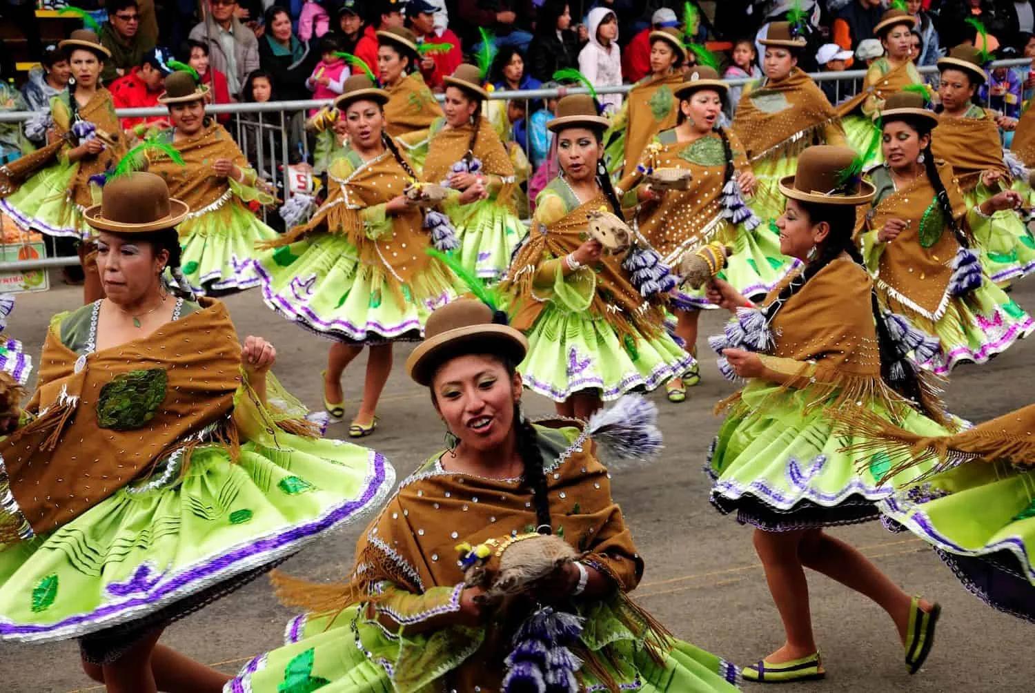 Grupo de dançarinas em trajes coloridos durante uma celebração de Carnaval.