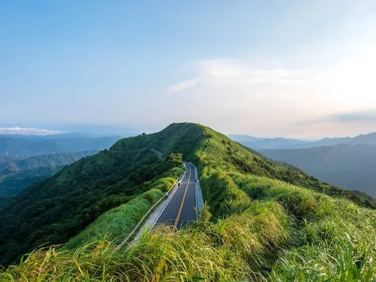 carro a andar numa estrada no meio de uma montanha verde em taiwan