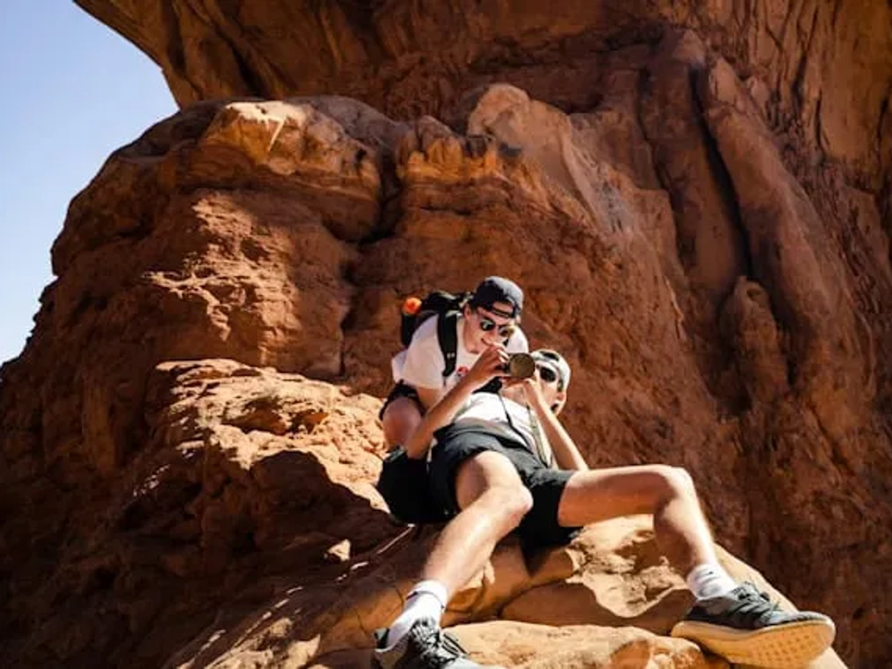 dois amigos numa montanha castanha a tirar uma foto