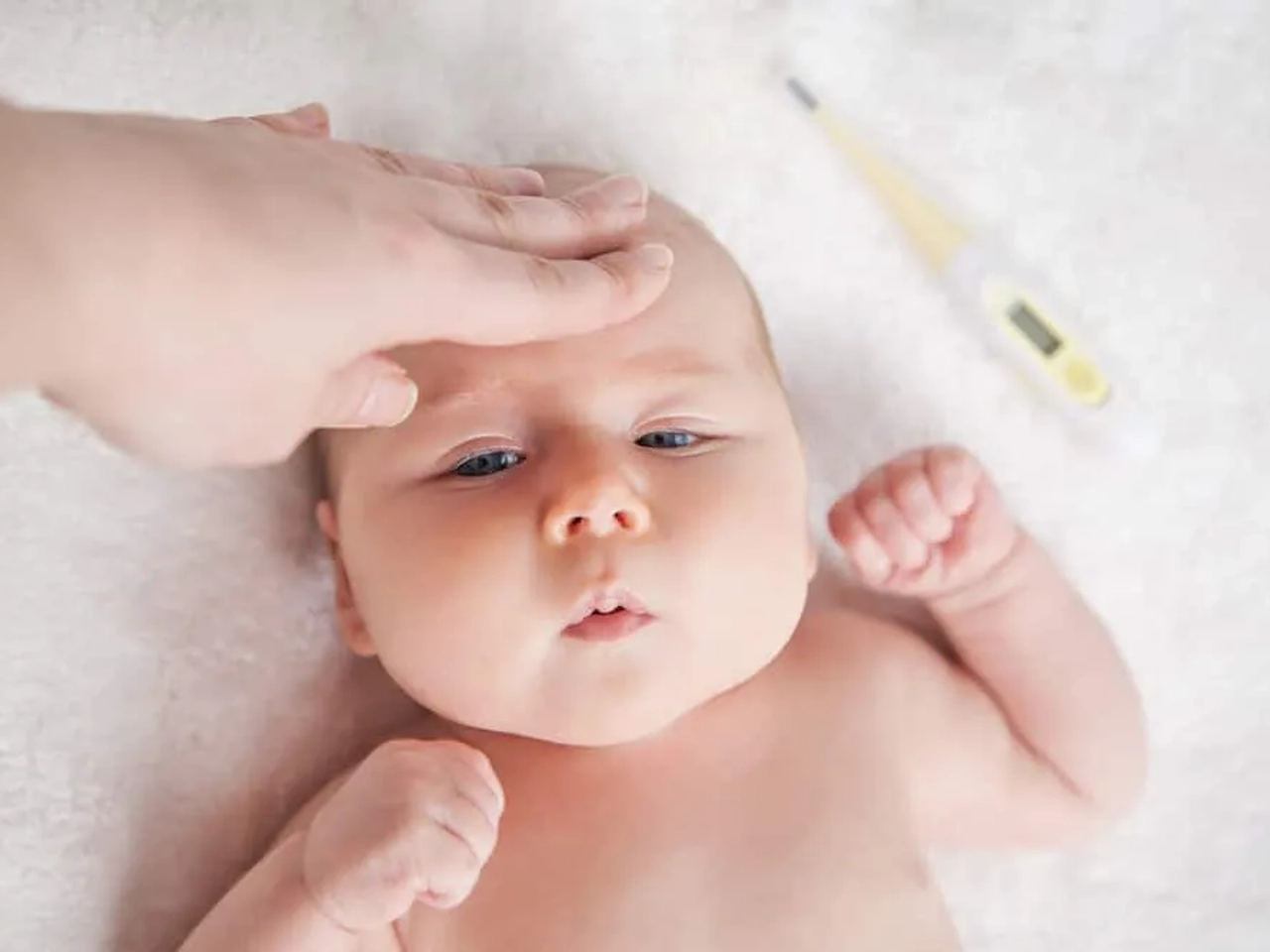 pessoa a medir temperatura de um bebe