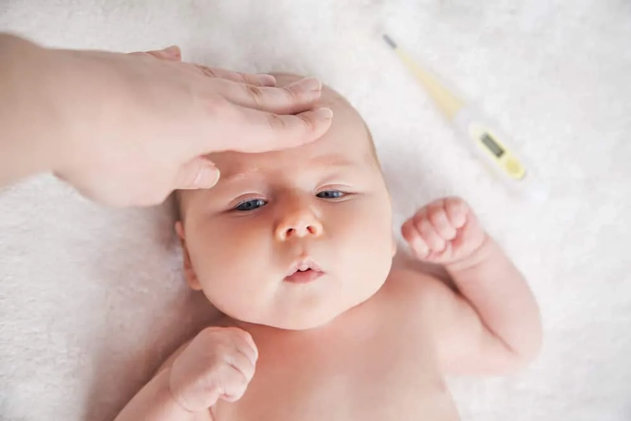 pessoa a medir temperatura de um bebe