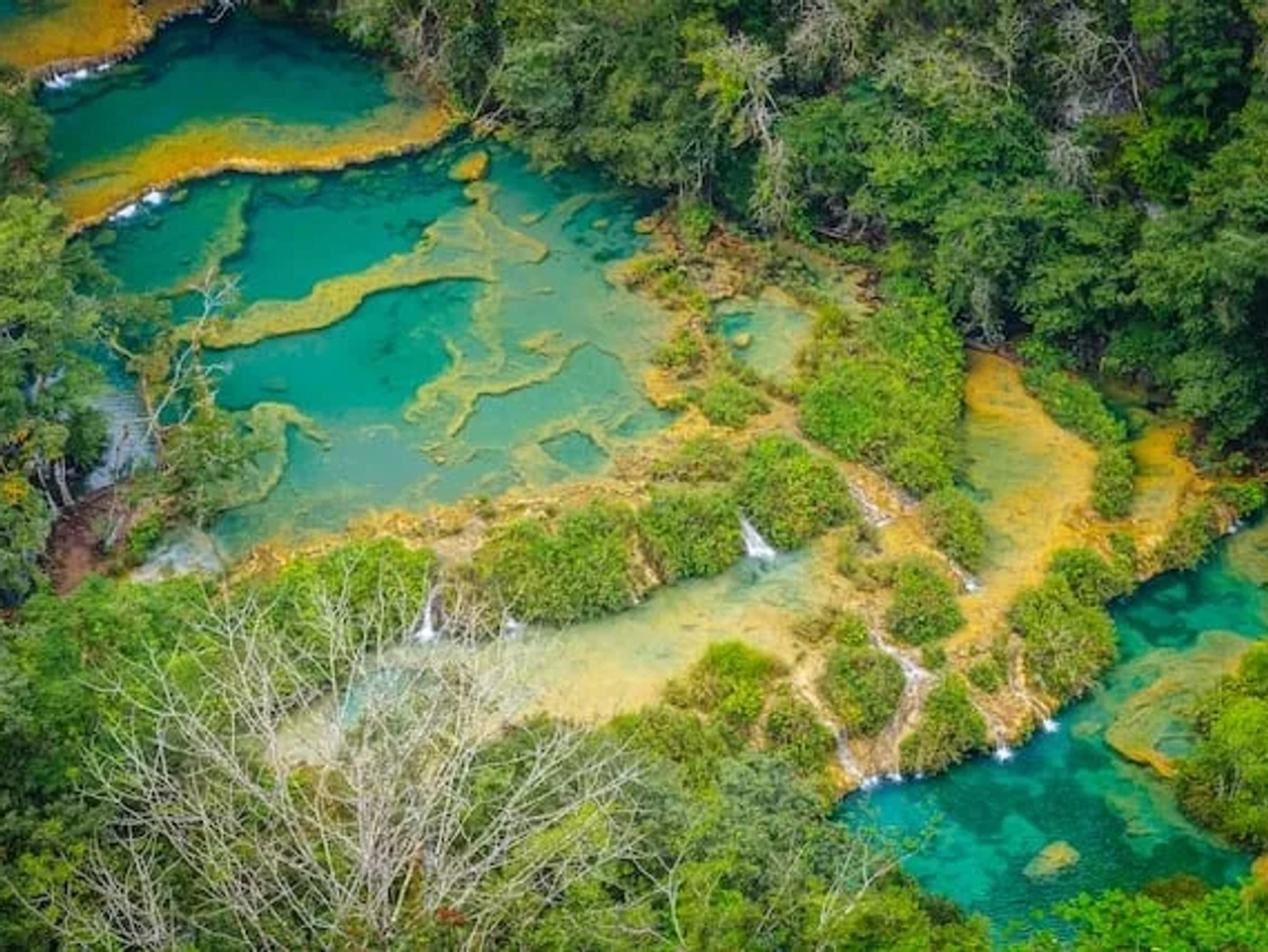 água azul turquesa com arbustos verdes em Lanquen, Guatemala